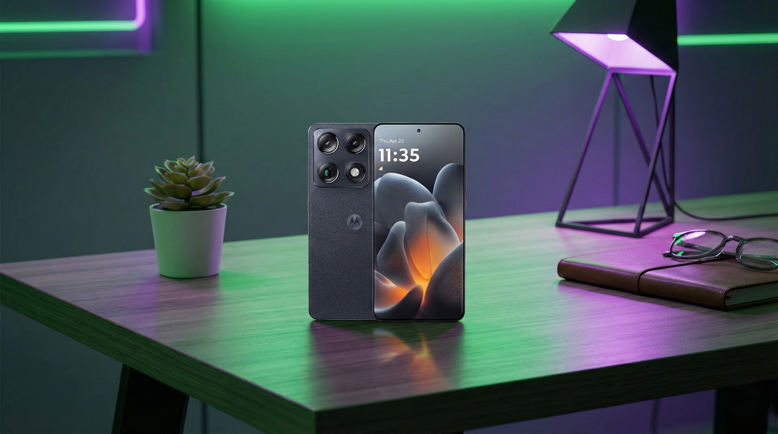 Motorola Signature color gris oscuro sobre un escritorio de madera con iluminación ambiental neón verde y morada. Se aprecia la pantalla de bloqueo encendida y el módulo trasero de triple cámara de 50MP.